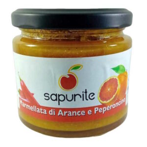 Un barattolo di marmellata di arance e peperoncino su uno sfondo bianco.